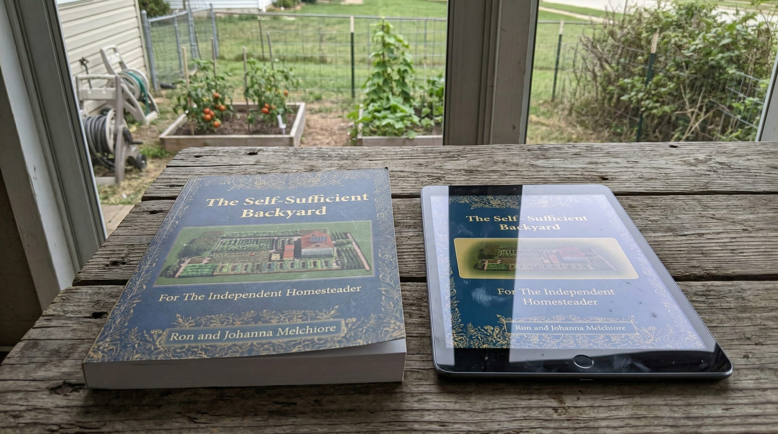 The Self-Sufficient Backyard physical book and tablet